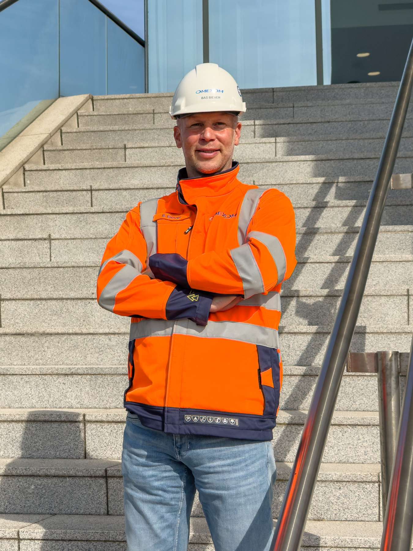 Omexom-medewerker in veiligheidskleding en helm op een projectlocatie